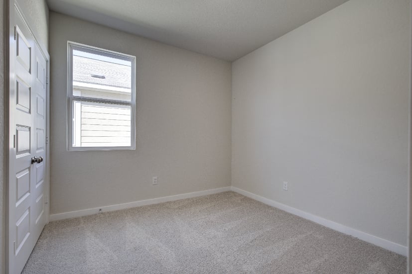 A room with white walls and a window.
