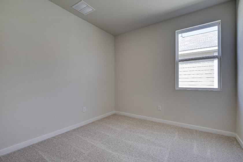 A room with a window and a carpet.