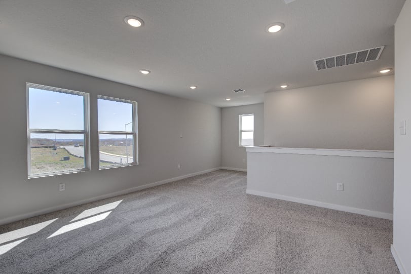 A room with windows and a white wall.