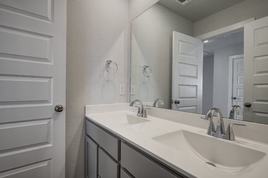 A bathroom with a large mirror.