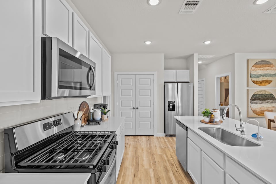 A kitchen with white cabinets.