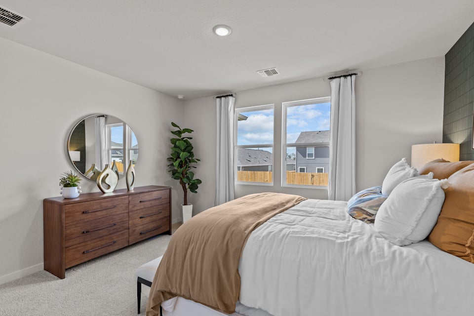 A bedroom with a large window.