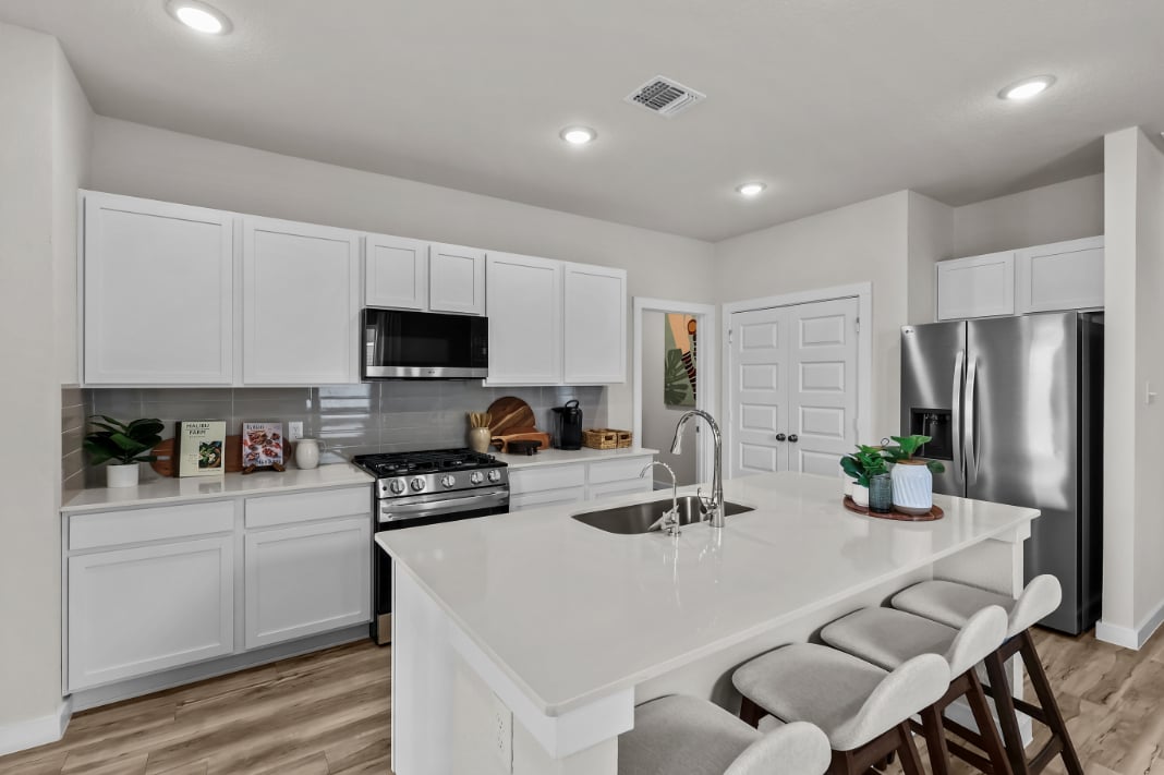 A kitchen with white cabinets.