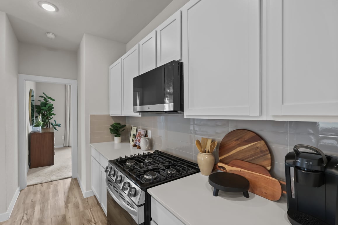 A kitchen with white cabinets.