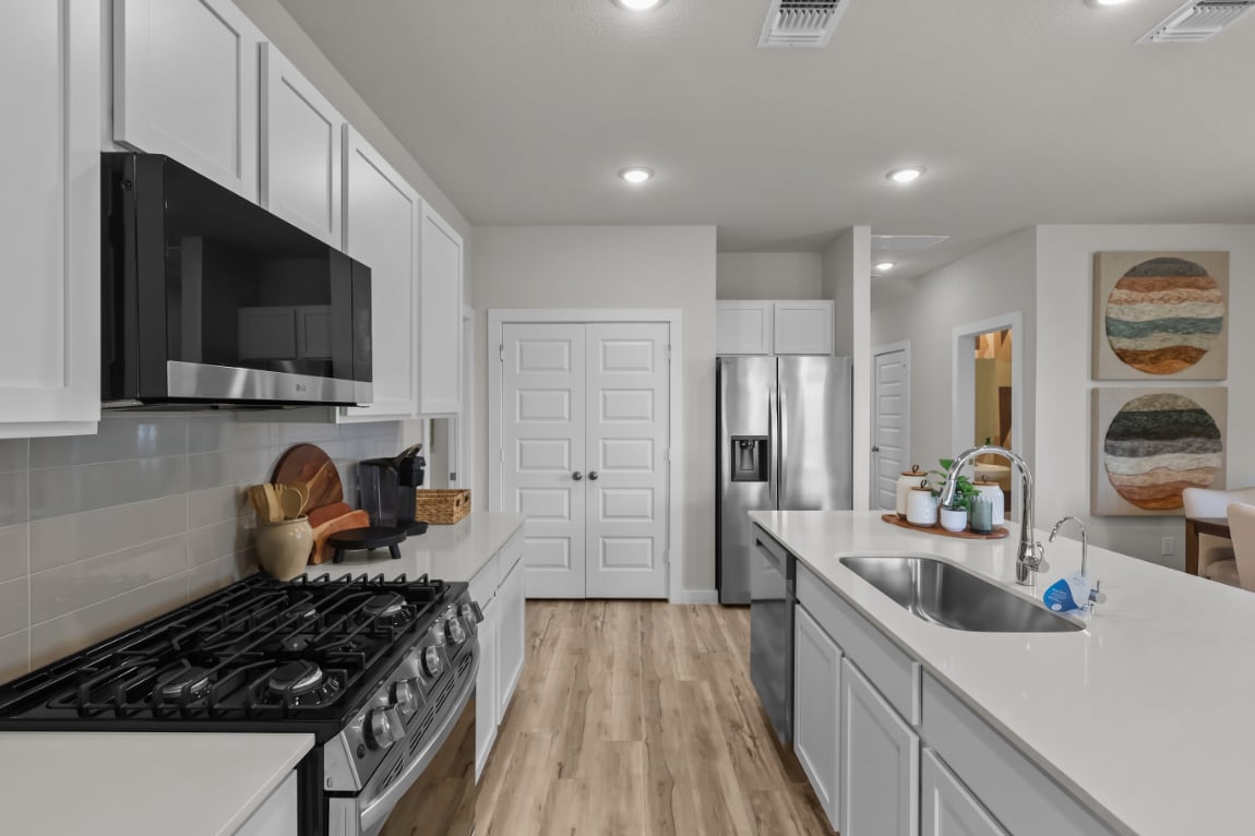 A kitchen with white cabinets.