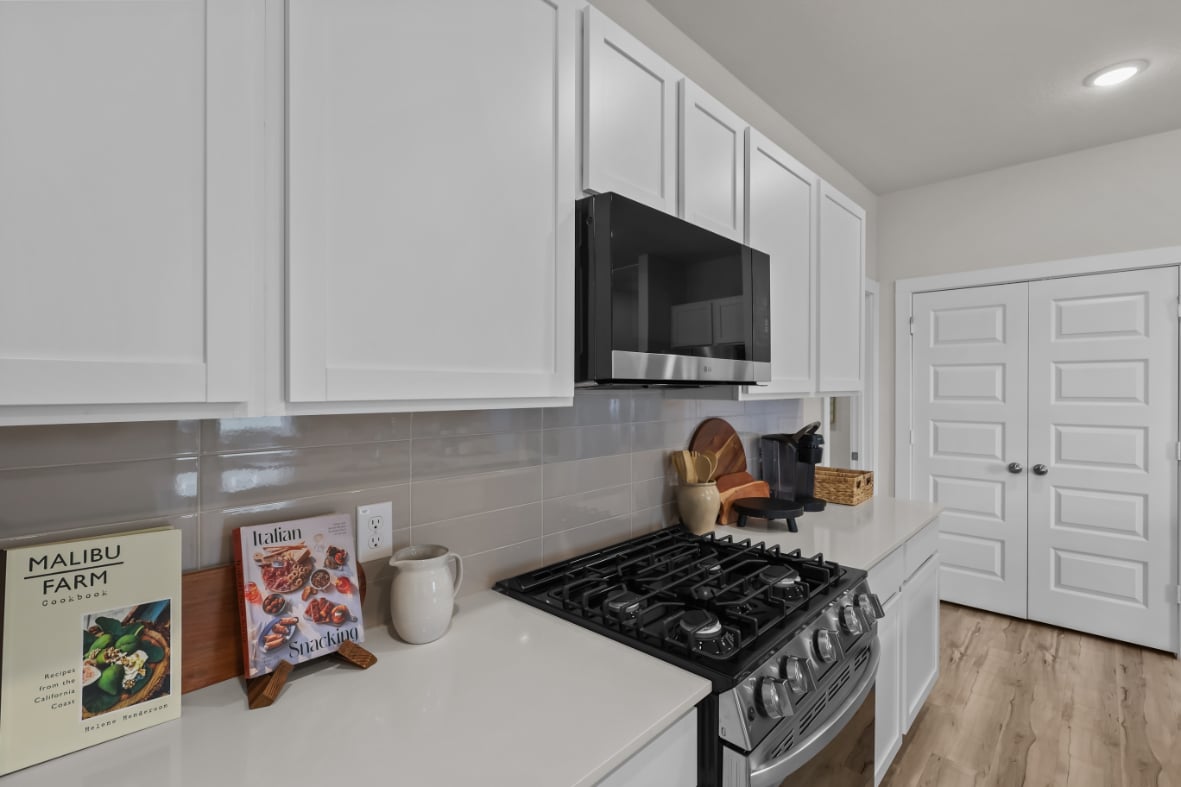 A kitchen with white cabinets.