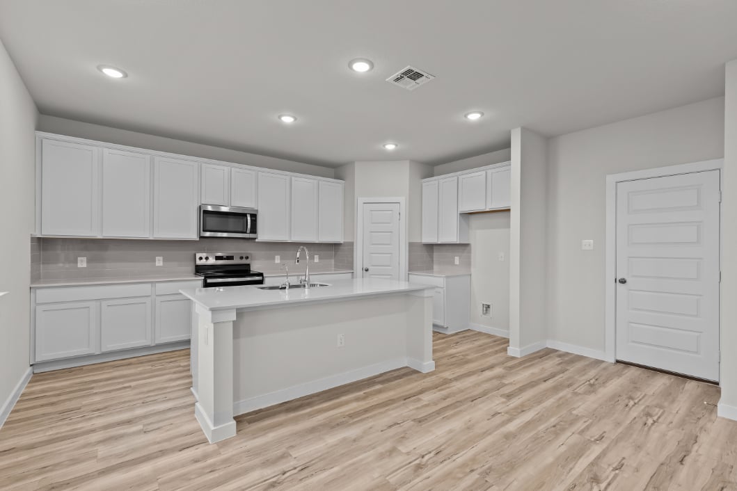 A kitchen with white cabinets.
