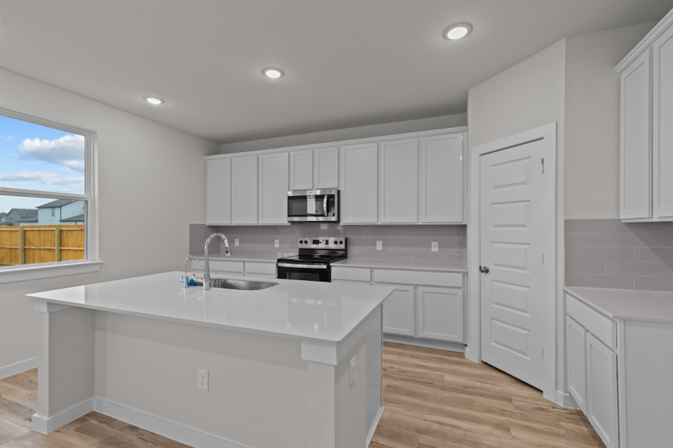 A kitchen with white cabinets.