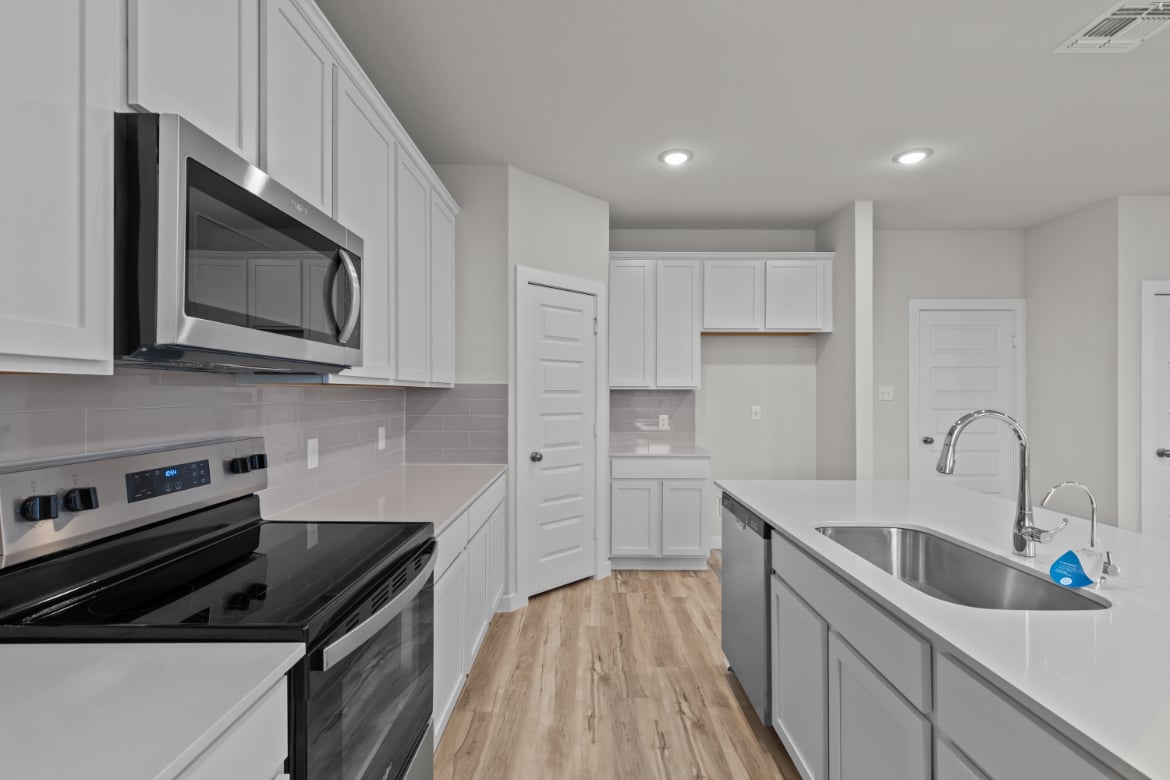 A kitchen with white cabinets.