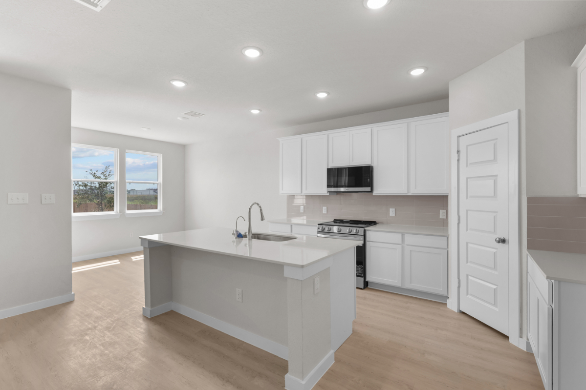 A kitchen with white cabinets.
