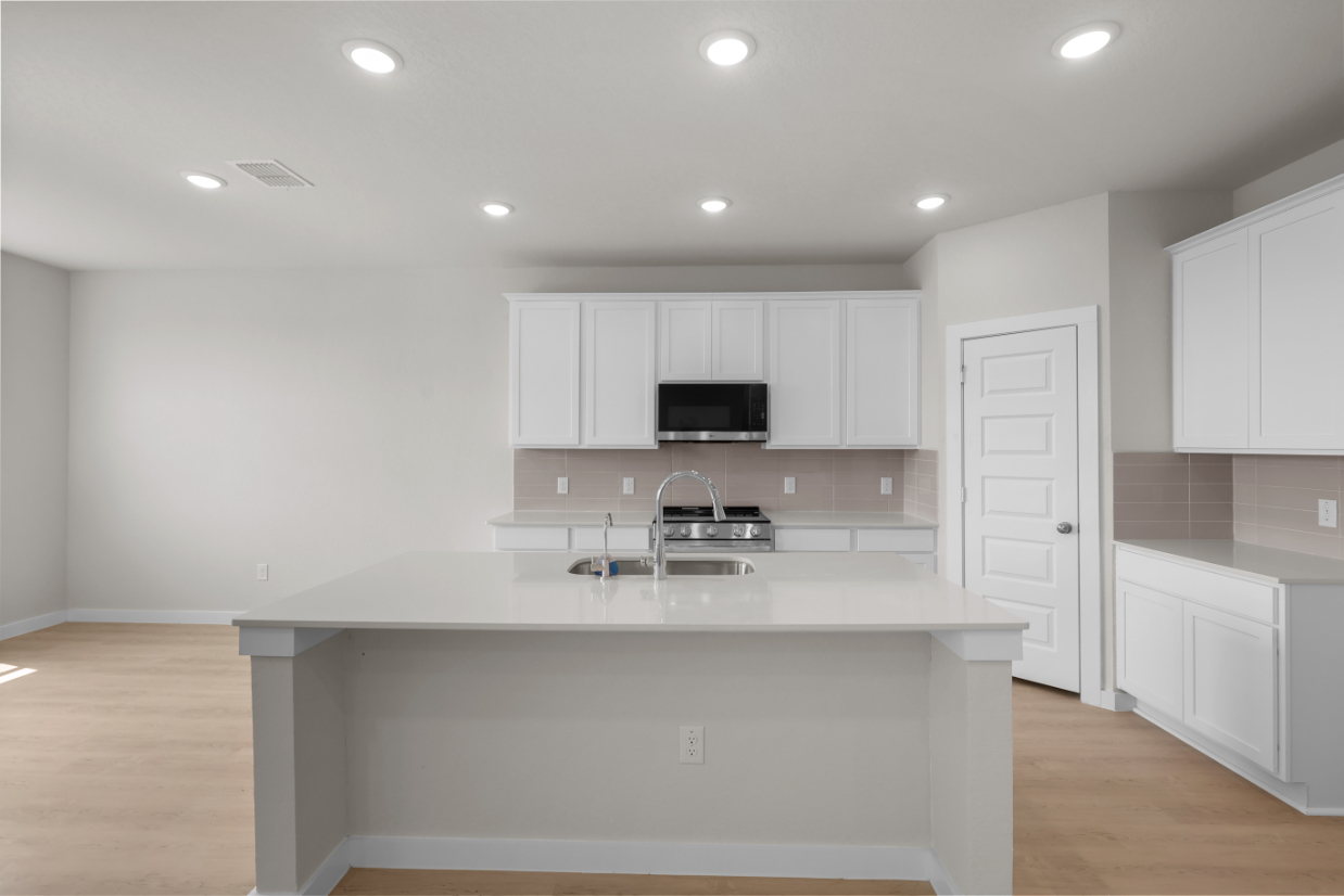 A kitchen with white cabinets.