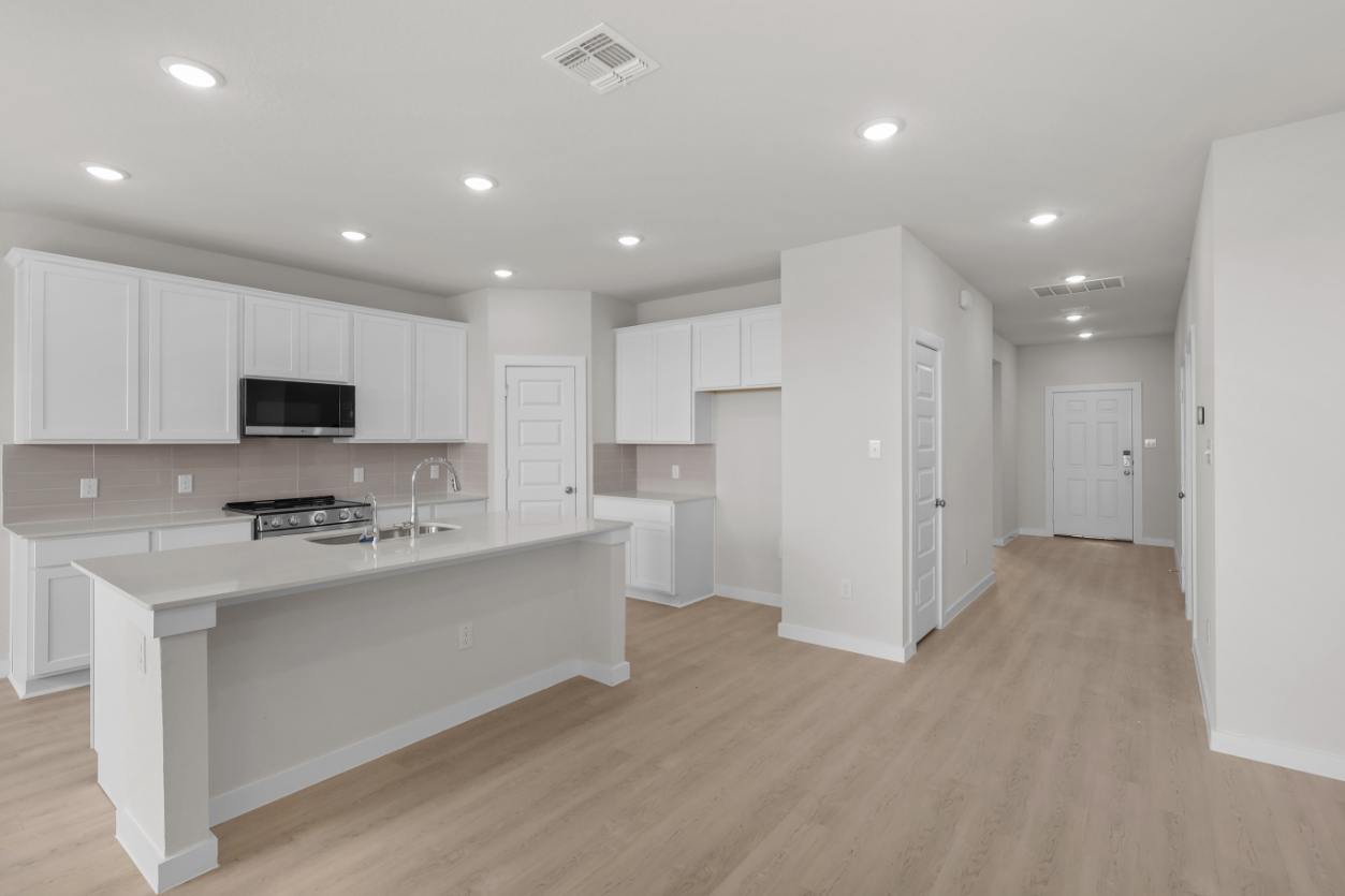 A kitchen with white cabinets.
