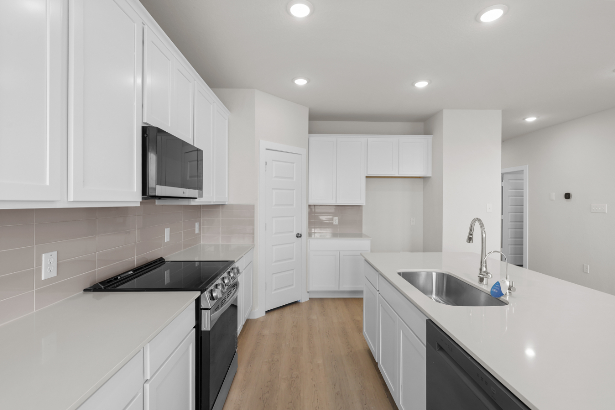 A kitchen with white cabinets.