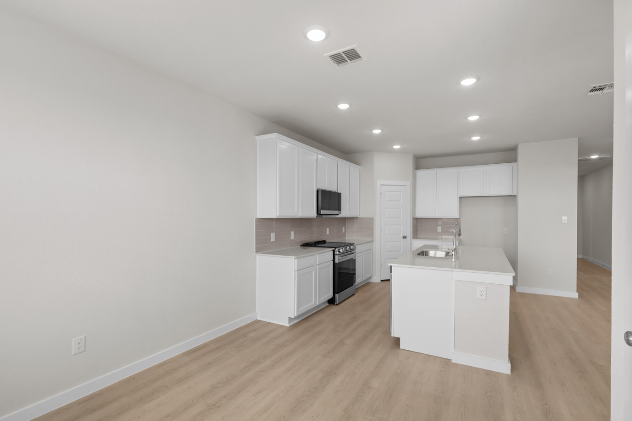 A kitchen with white cabinets.