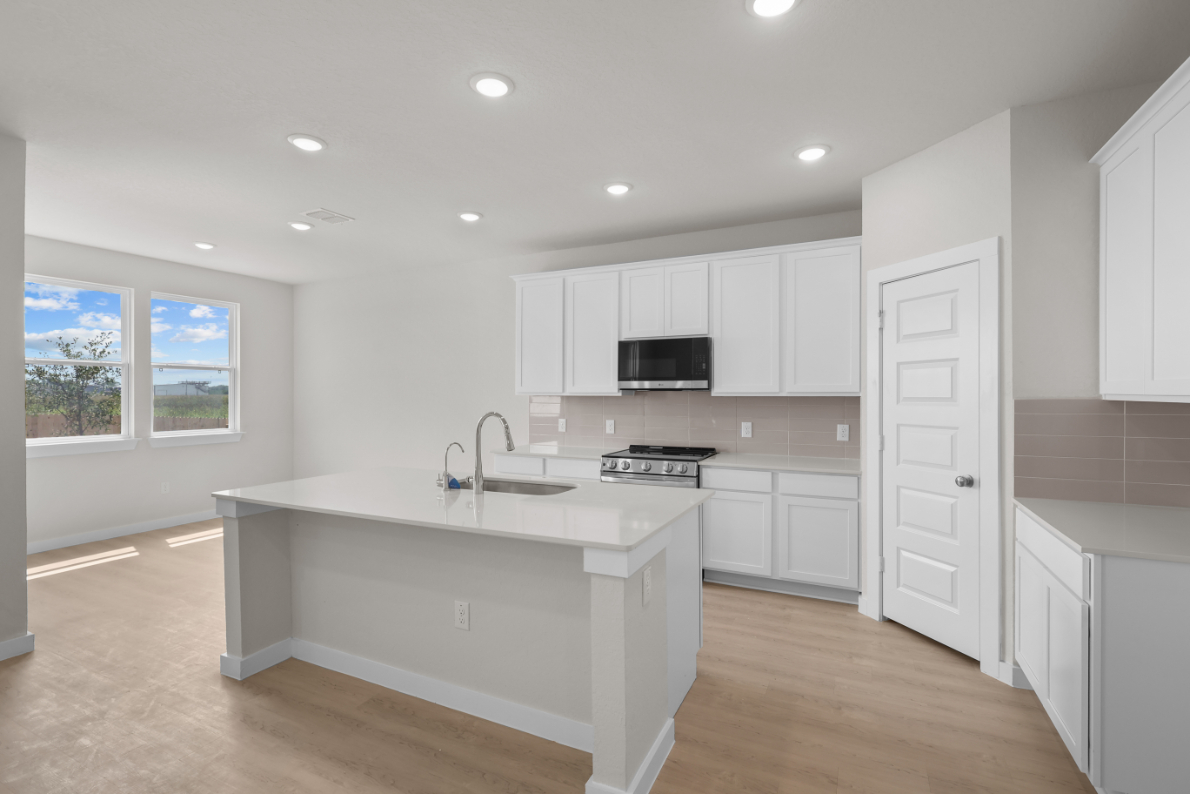 A kitchen with white cabinets.