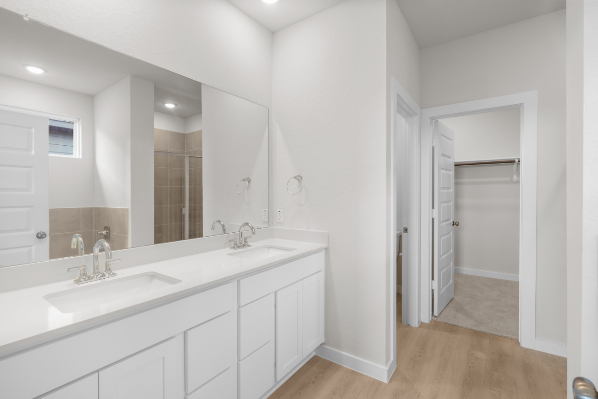 A bathroom with white cabinets.