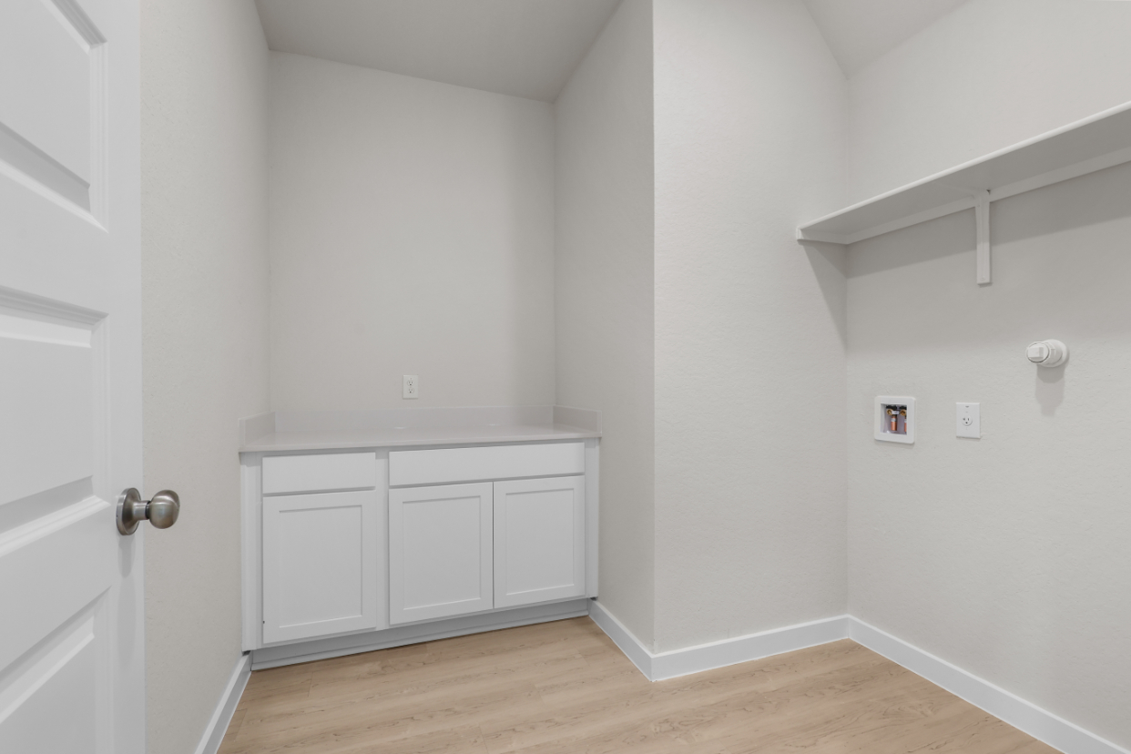A white room with a wood floor.