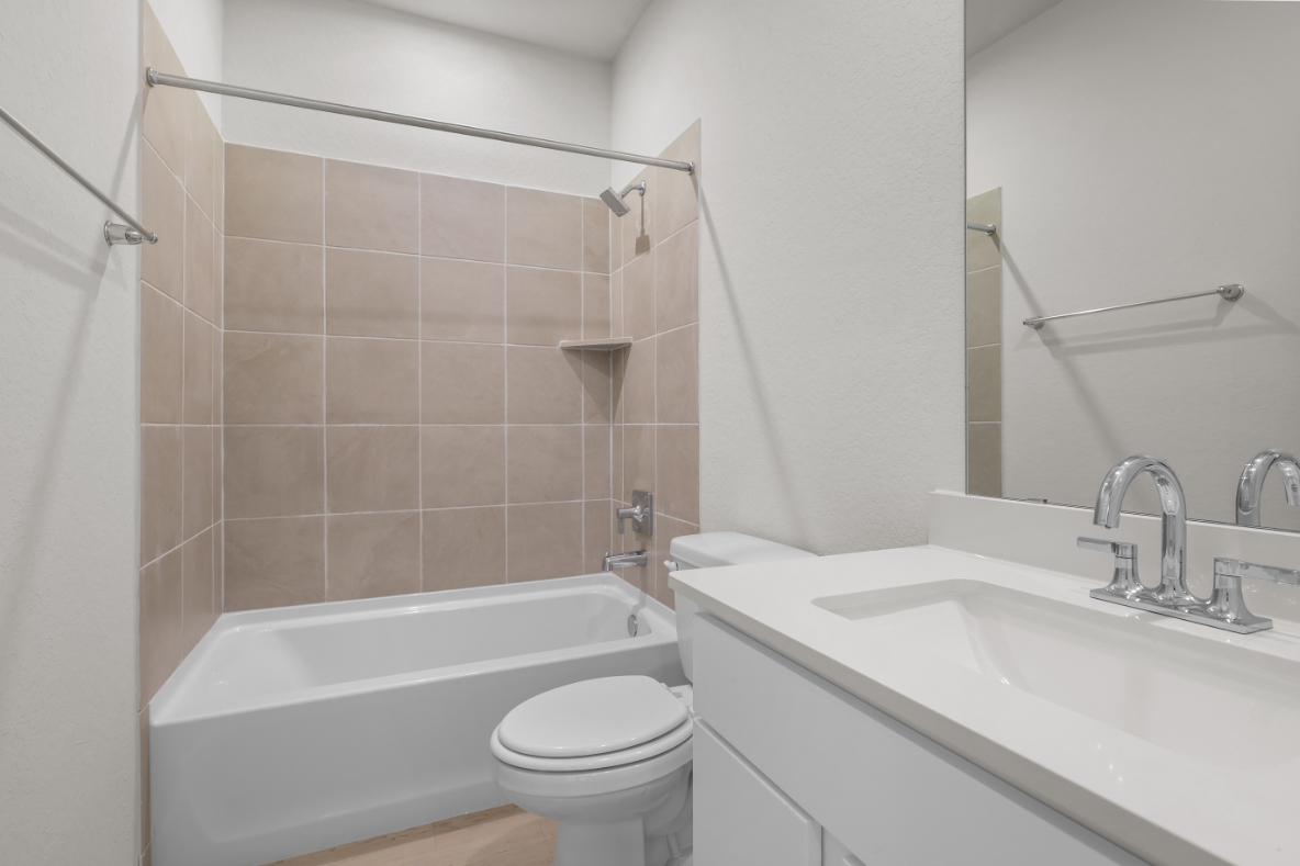 A bathroom with a tub sink and toilet.