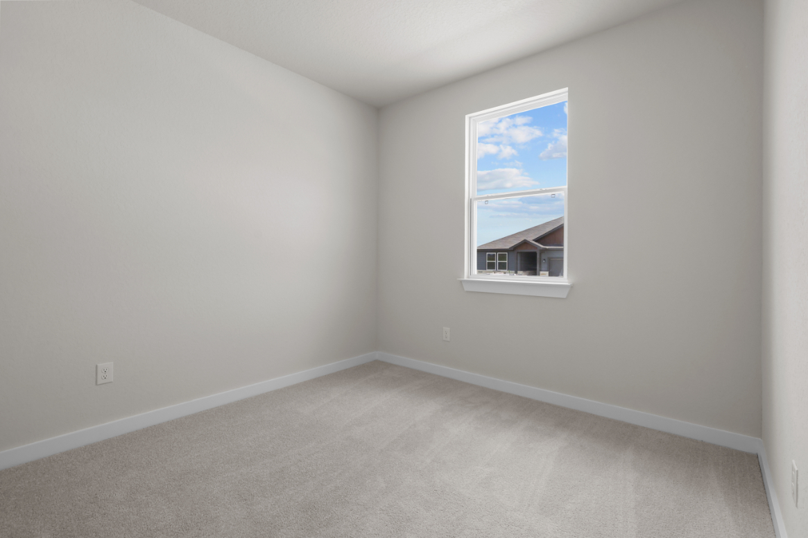 A room with a window and a rug.
