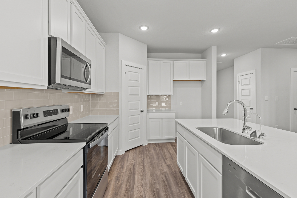 A kitchen with white cabinets.