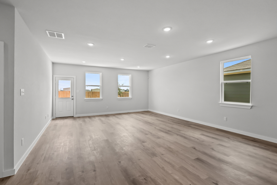A room with a wood floor and windows.