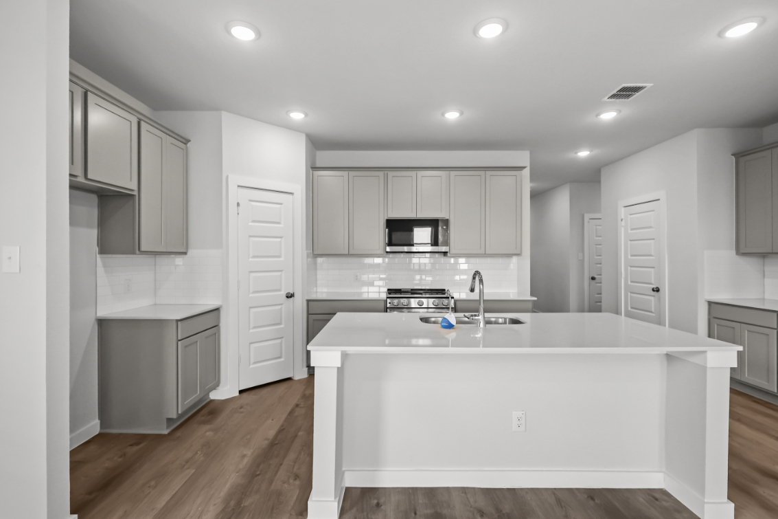 A kitchen with white cabinets.