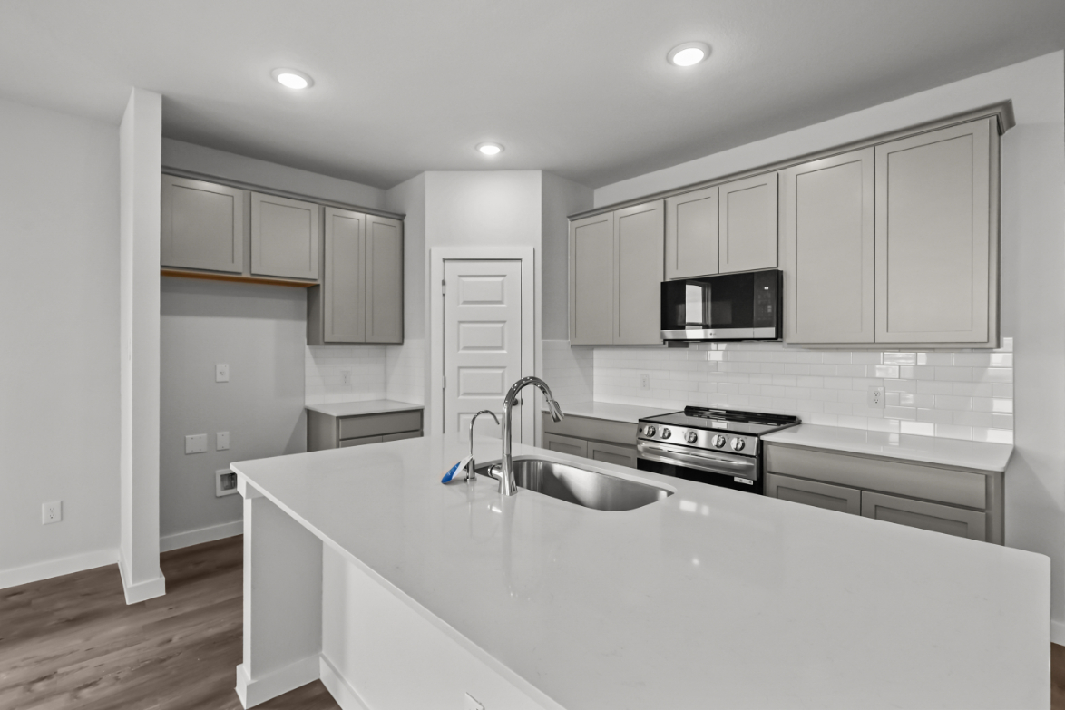 A kitchen with white cabinets.