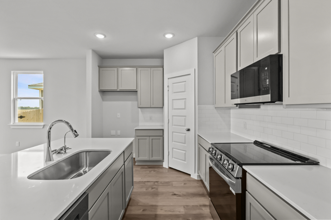 A kitchen with white cabinets.