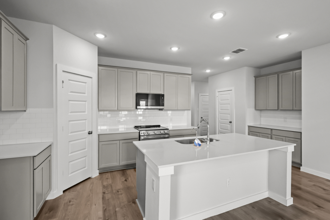 A kitchen with white cabinets.