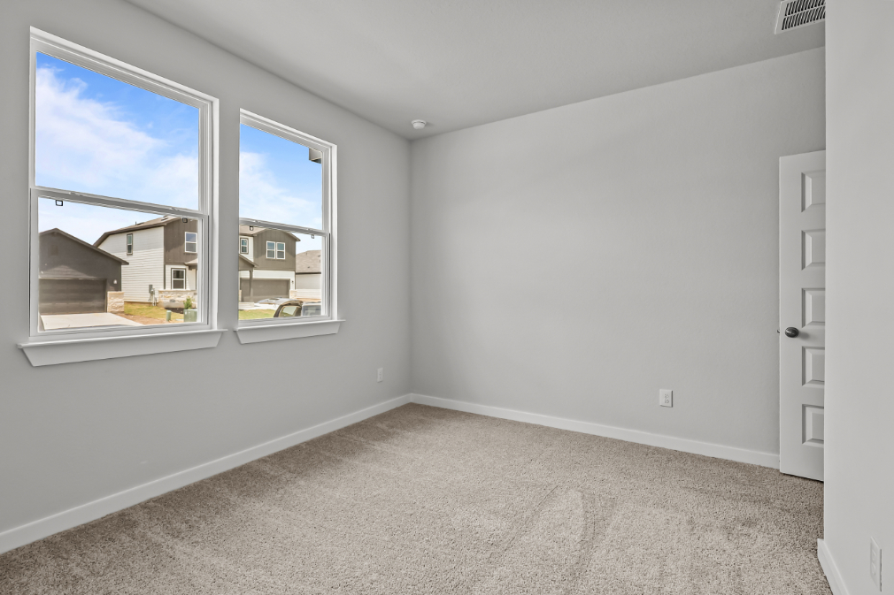 A room with a window and a carpet.