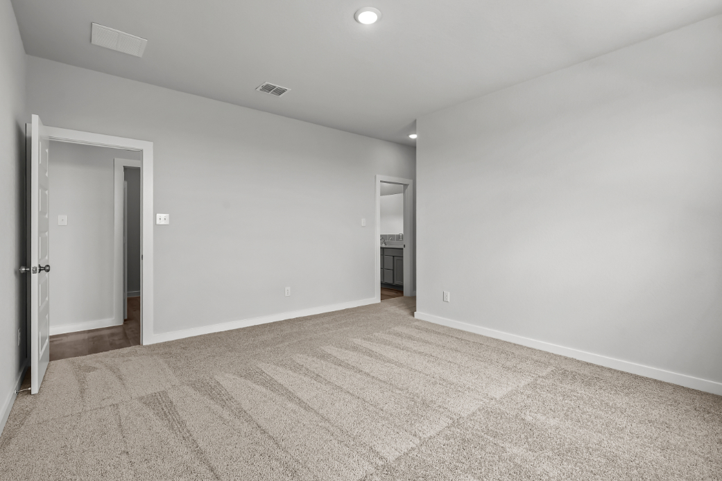 A room with a carpet and a door.