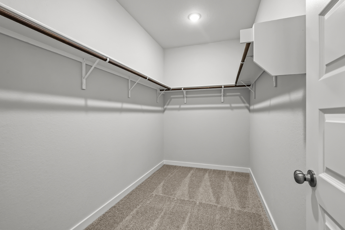A white tiled room with a metal railing.