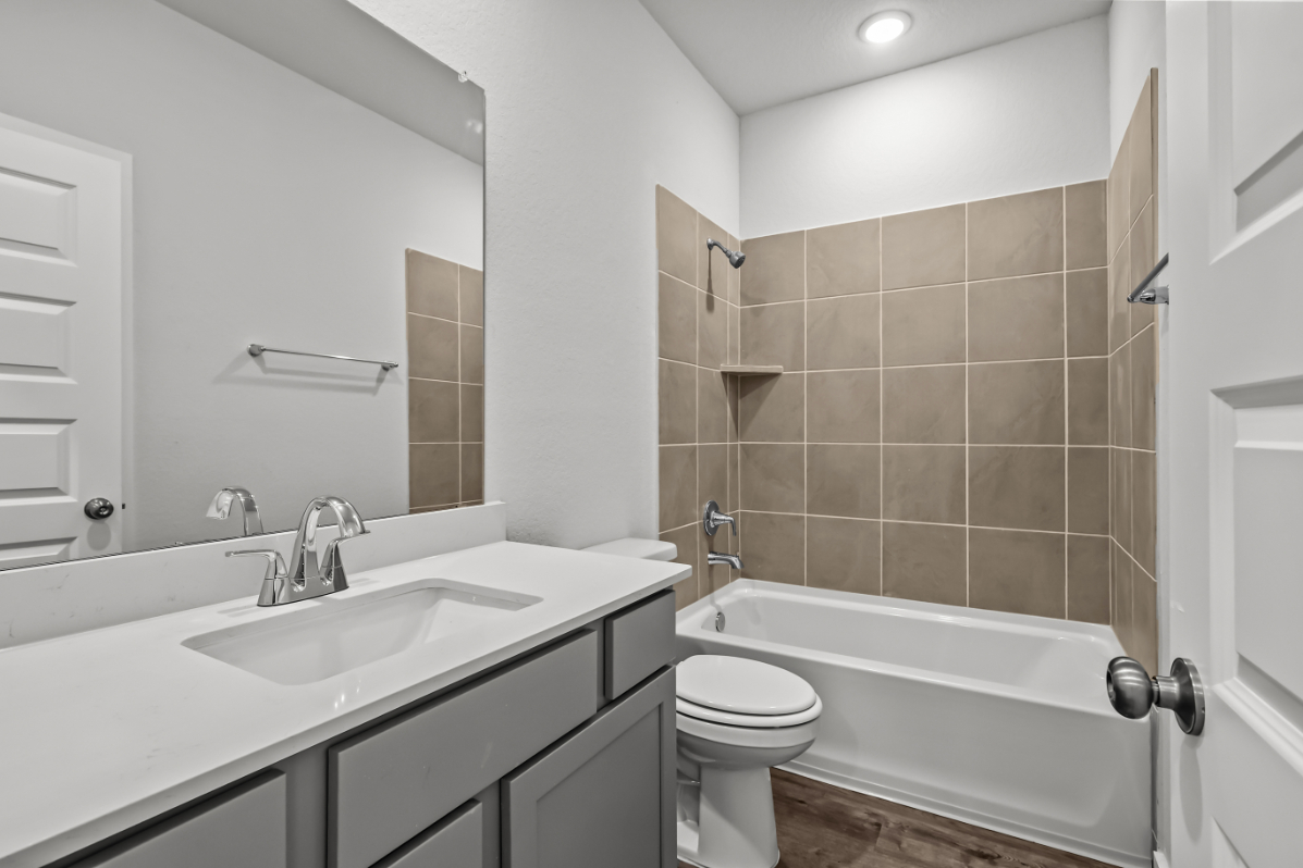 A bathroom with a tub sink and toilet.