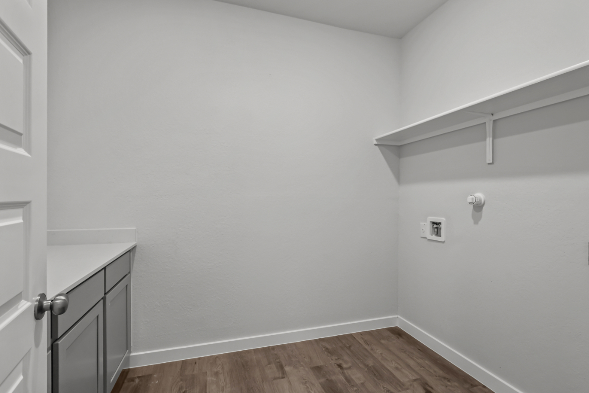 A white room with a wood floor.