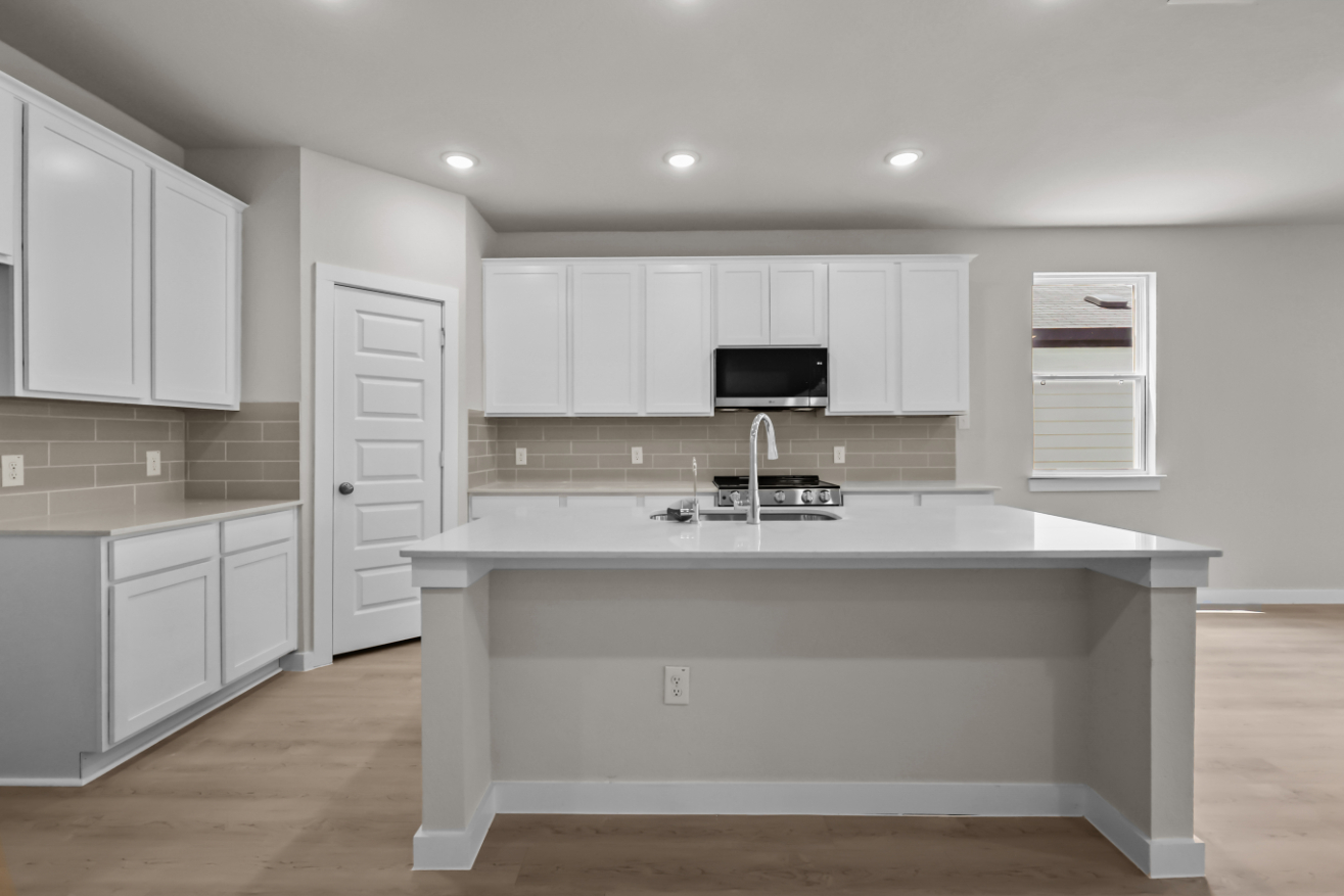 A kitchen with white cabinets.