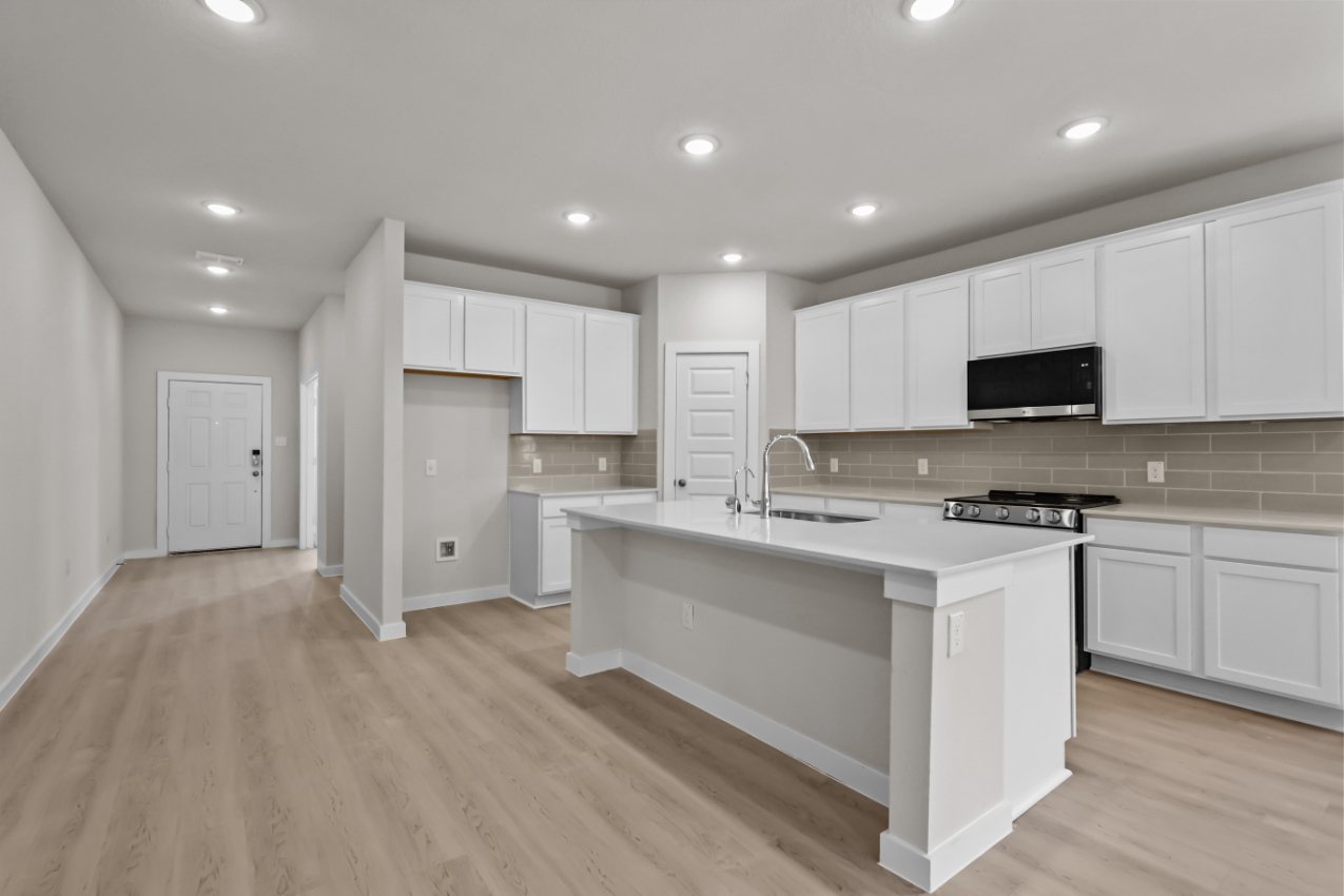 A kitchen with white cabinets.
