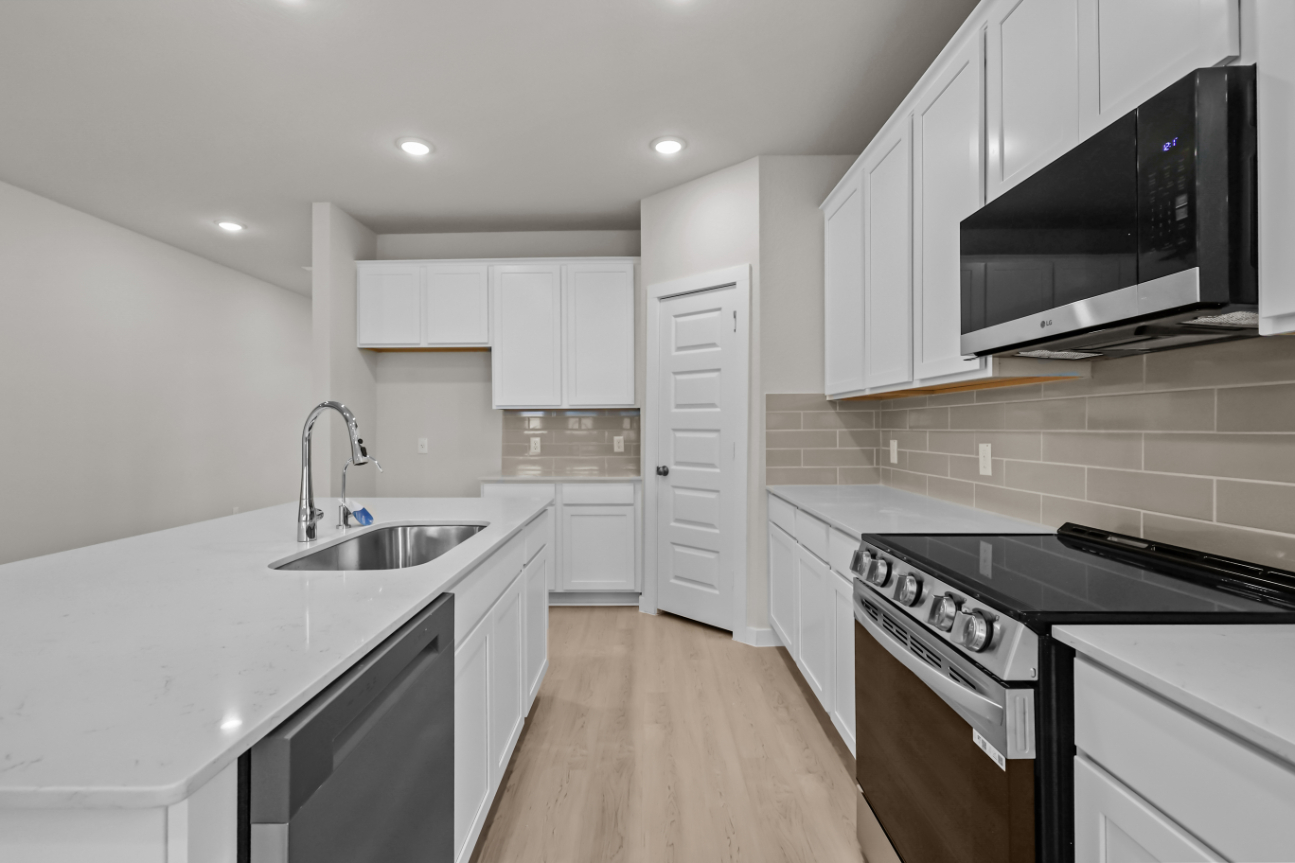 A kitchen with white cabinets.