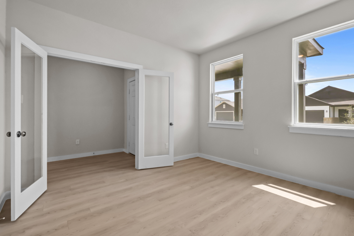 A room with a wood floor and a window.