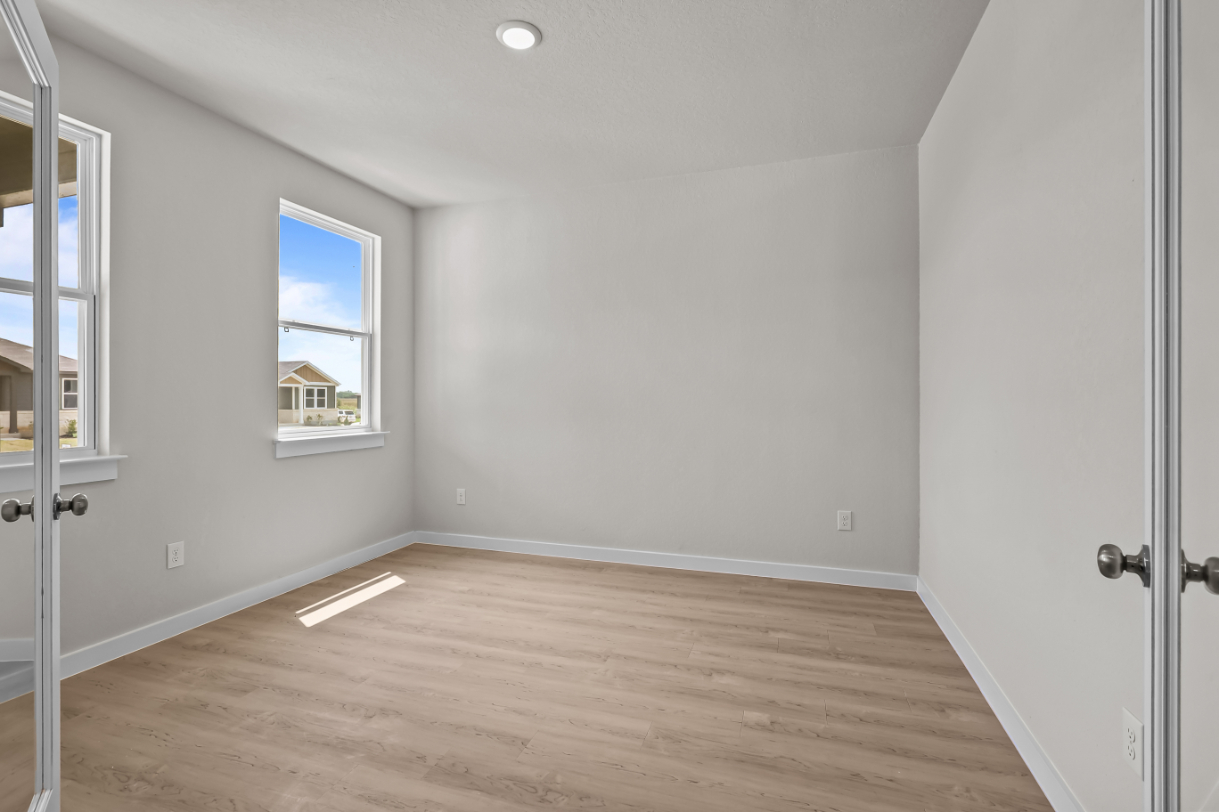 A room with a wood floor and a window.