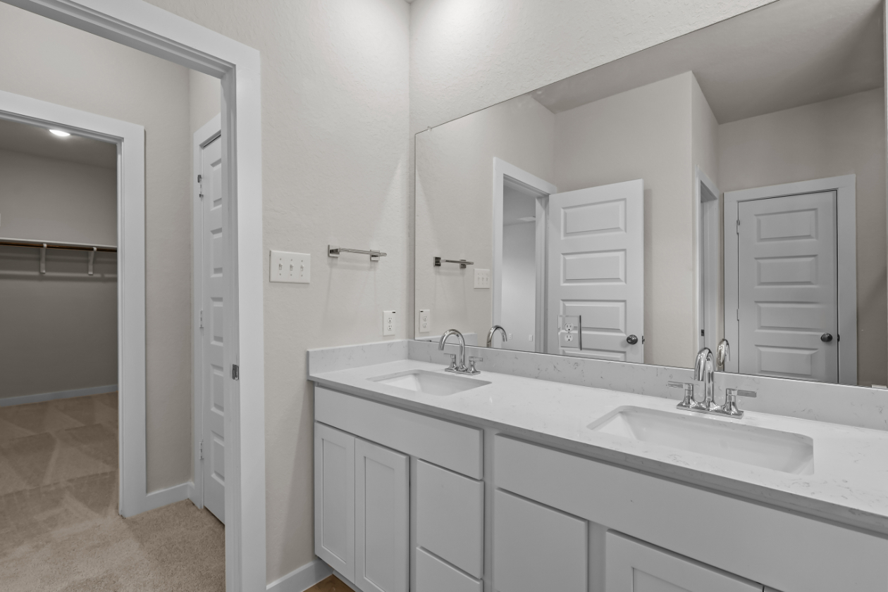A bathroom with white cabinets.