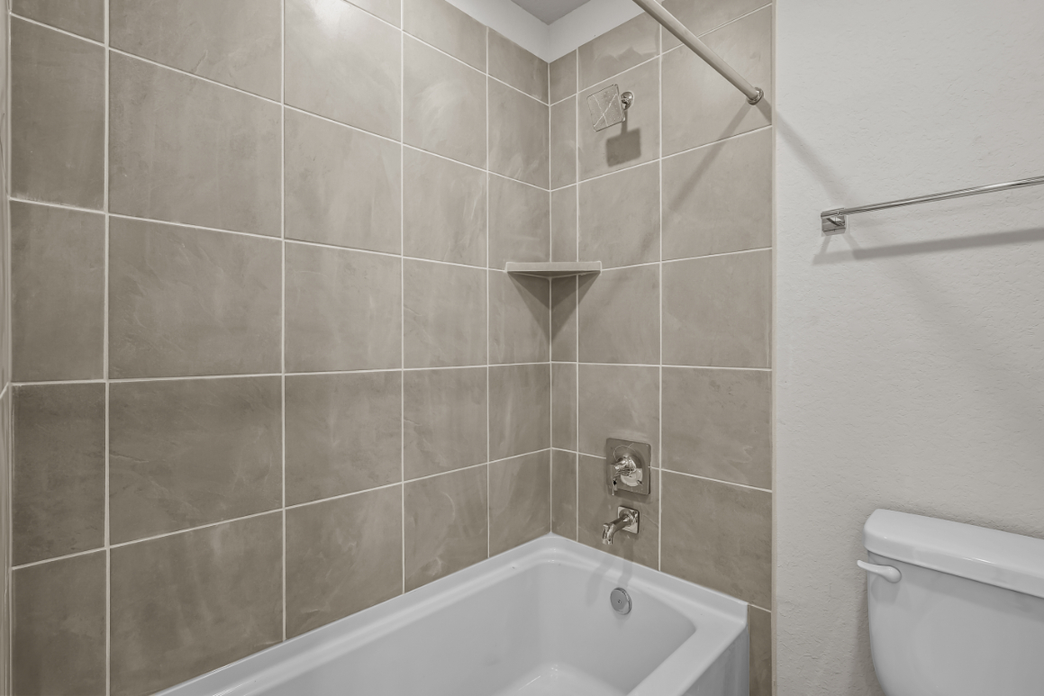 A bathroom with a bathtub and toilet.