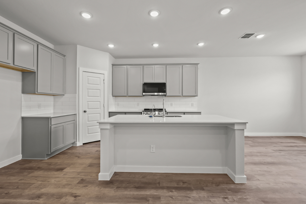 A kitchen with white cabinets.