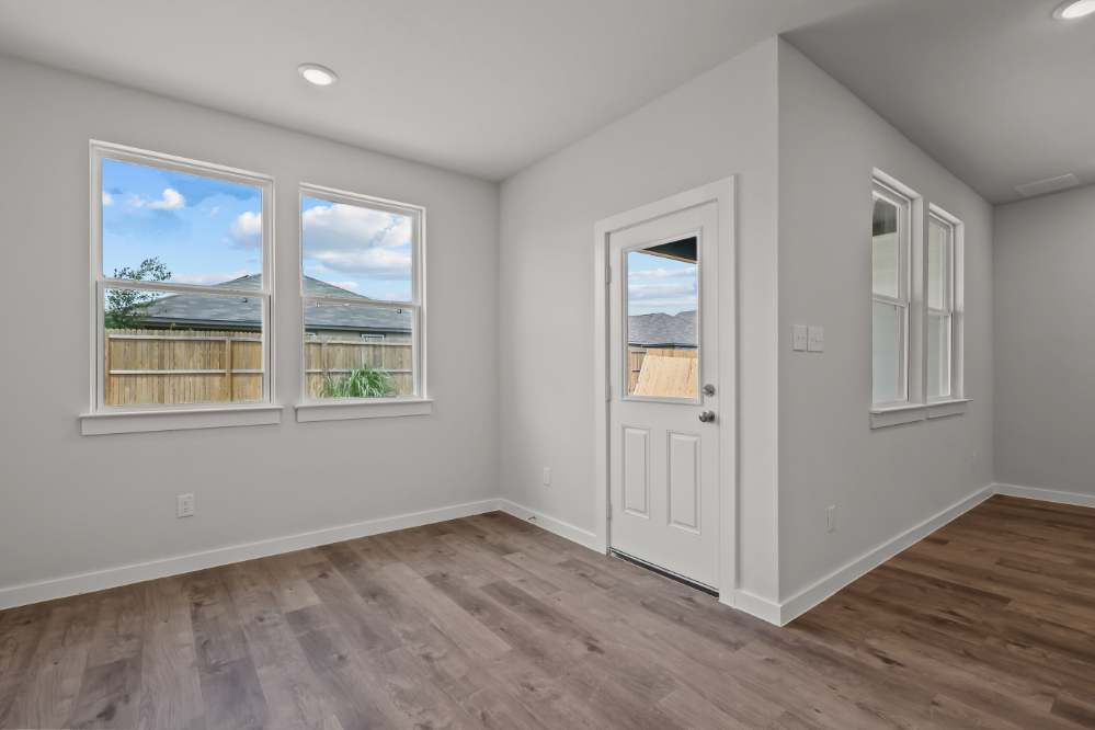 A room with a wood floor and windows.