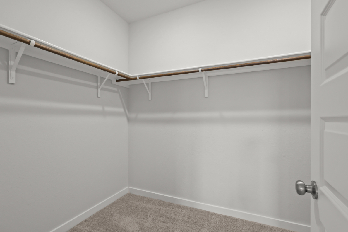A white wall with a metal bar.