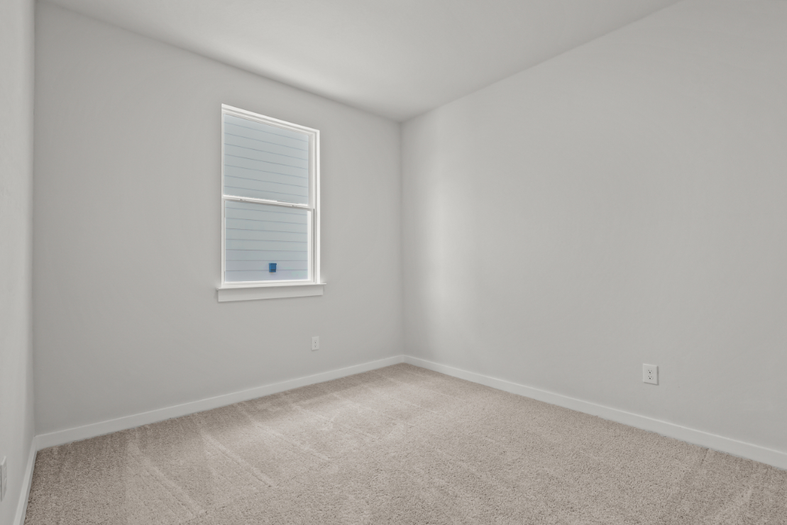 A room with a window and carpet.