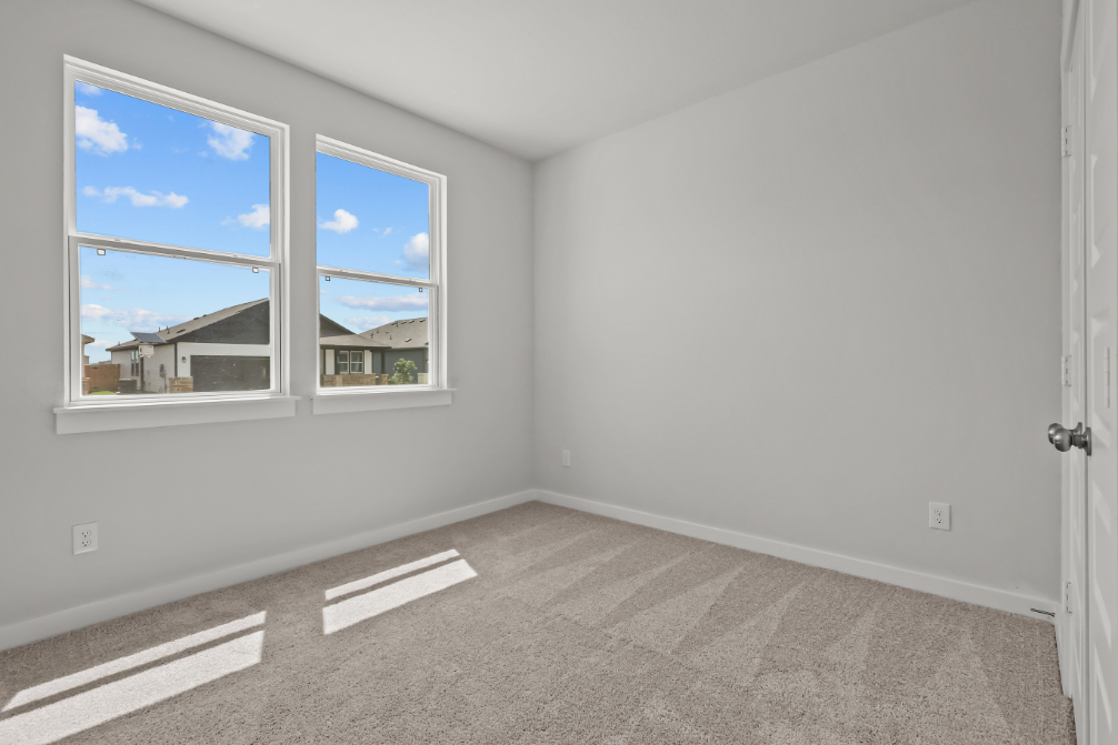 A room with a window and a carpet.