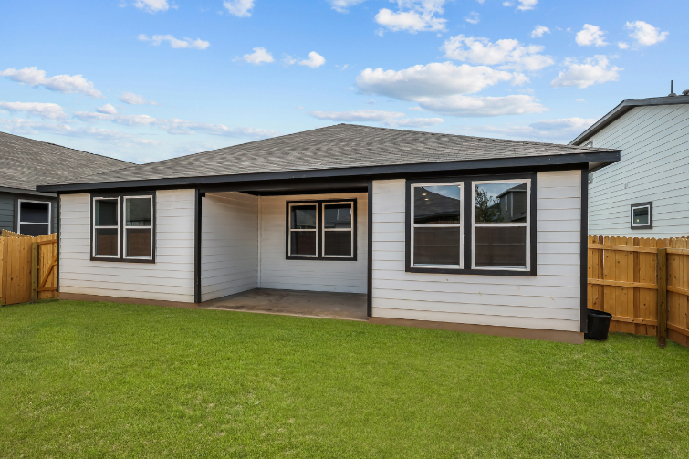 A house with a fence and grass.