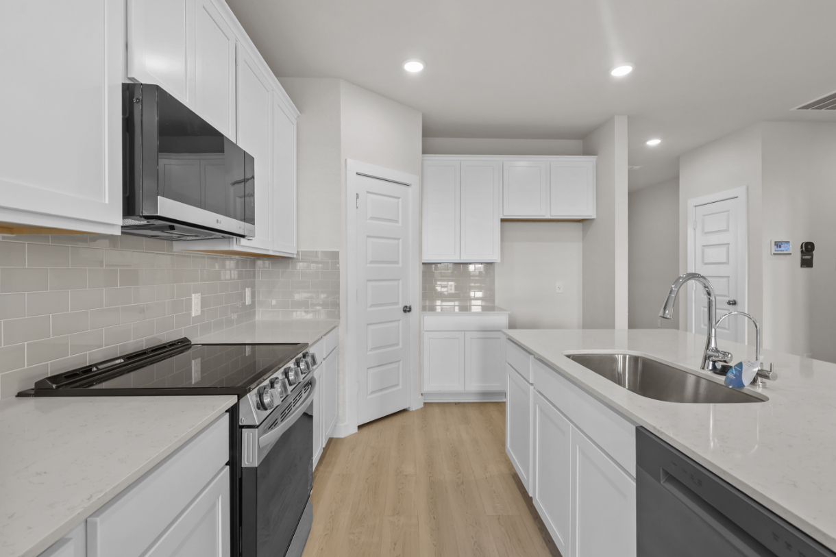 A kitchen with white cabinets.