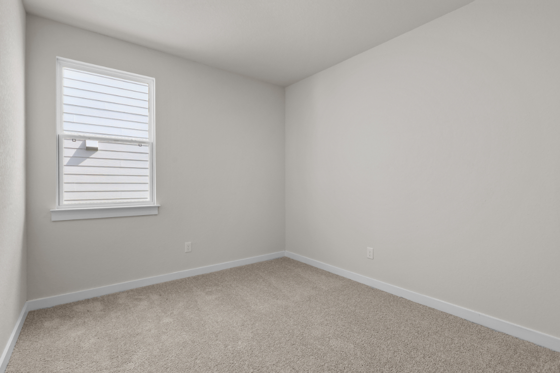 A room with a window and a carpet.