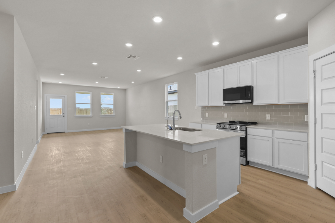 A kitchen with white cabinets.
